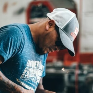 Worker grinding metal in workshop, sparks flying